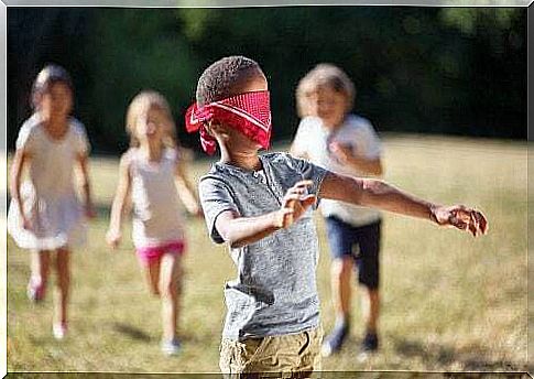 Blindfolded child plays with others