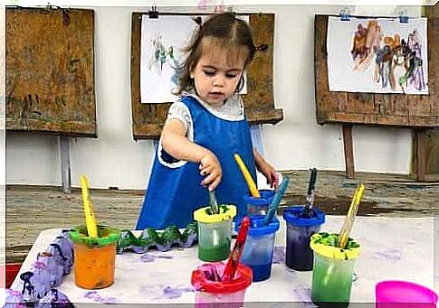 little girl playing with colors and painting pictures