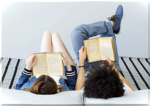 Two children are reading while lying on the bed.