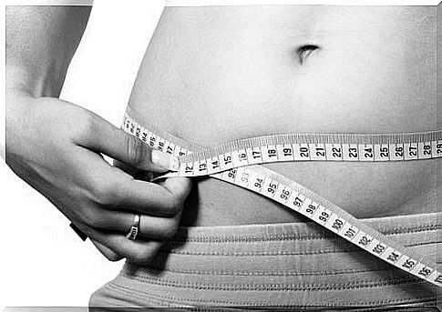 A woman measures the waistline after giving birth.