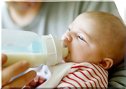 Newborn takes milk from the bottle