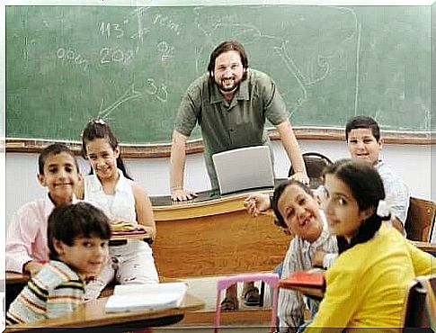 Happy teacher and pupils in the classroom.