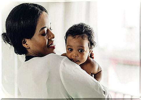 Smiling mother holding her baby in her arms.