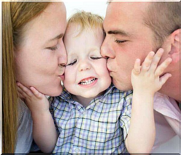 Dad and mom kiss the baby