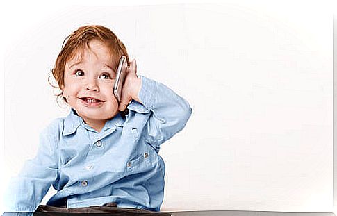 Small child smiling and talking on the phone.