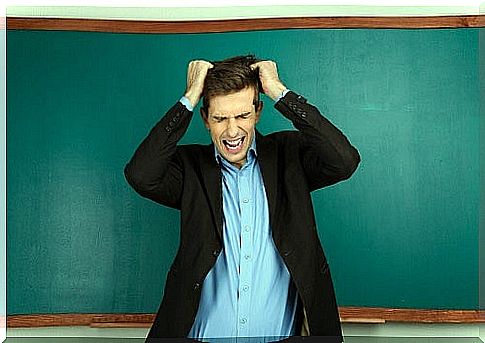 man tears his hair in front of blackboard