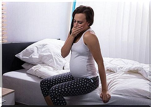 newly woken pregnant woman yawns on bed