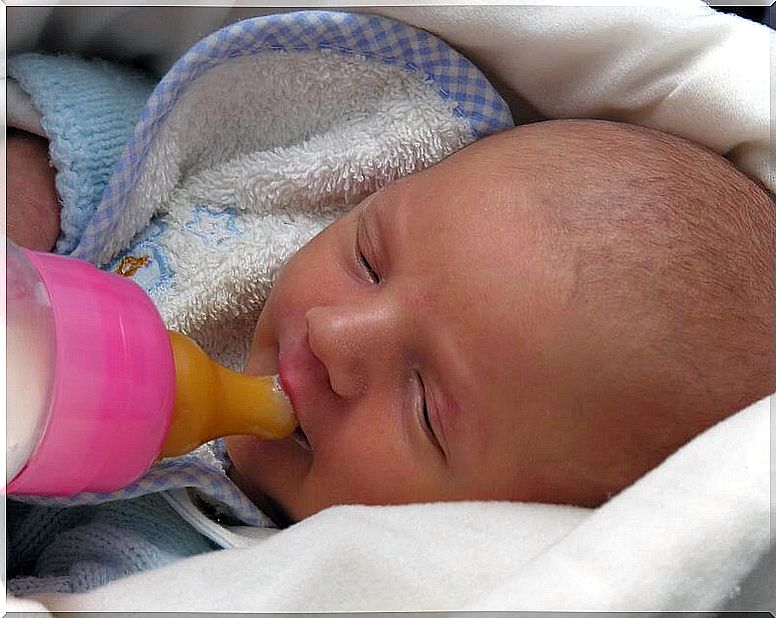 Newborn with baby bottle.