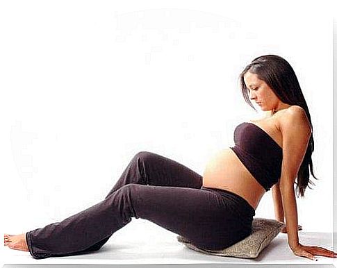 pregnant woman sitting on pillow 