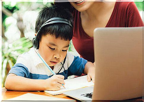 Mother helping her son to learn to write.